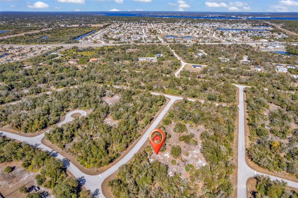 An aerial view shows a vacant, wooded residential lot marked with a red location pin — 7124 OBRIEN LANE, PORT CHARLOTTE, FL