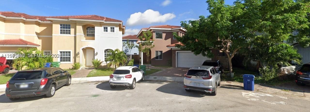 Two two-story suburban houses with tile roofs and driveways sit side-by-side on a street — 15631 SW 11th Ter, Miami FL 33194, MIAMI, FL