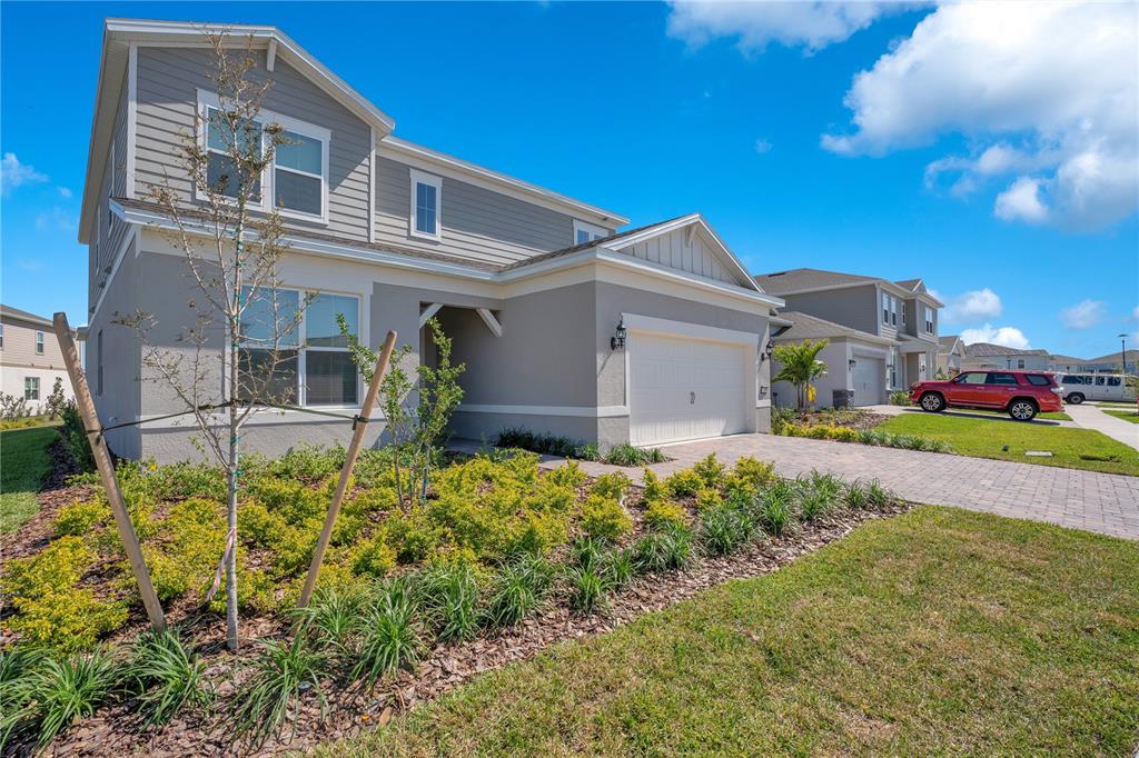 A two-story gray house with a paved driveway, a two-car garage, and landscaped front yard — 13231 PANAMA BEACH COURT, ORLANDO, FL