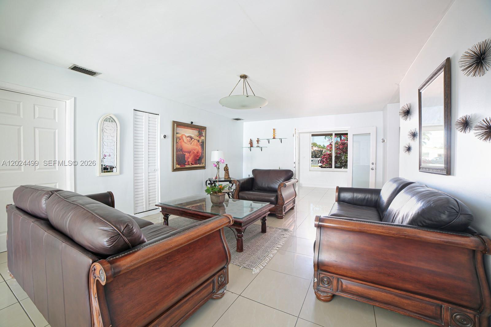 A living room features leather furniture, a glass-top coffee table, and tile flooring — 1380 71st St, Miami Beach FL 33141, MIAMI BEACH, FL