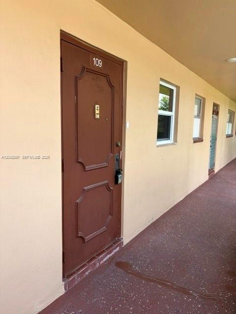 A brown door labeled 109 is set in a tan exterior wall along a walkway — 2741 N Pine Island Rd # 109, Sunrise FL 33322, SUNRISE, FL
