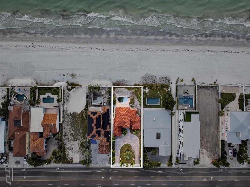 An aerial view shows a beachfront house with a red tile roof and swimming pool — 16116 GULF BOULEVARD, REDINGTON BEACH, FL