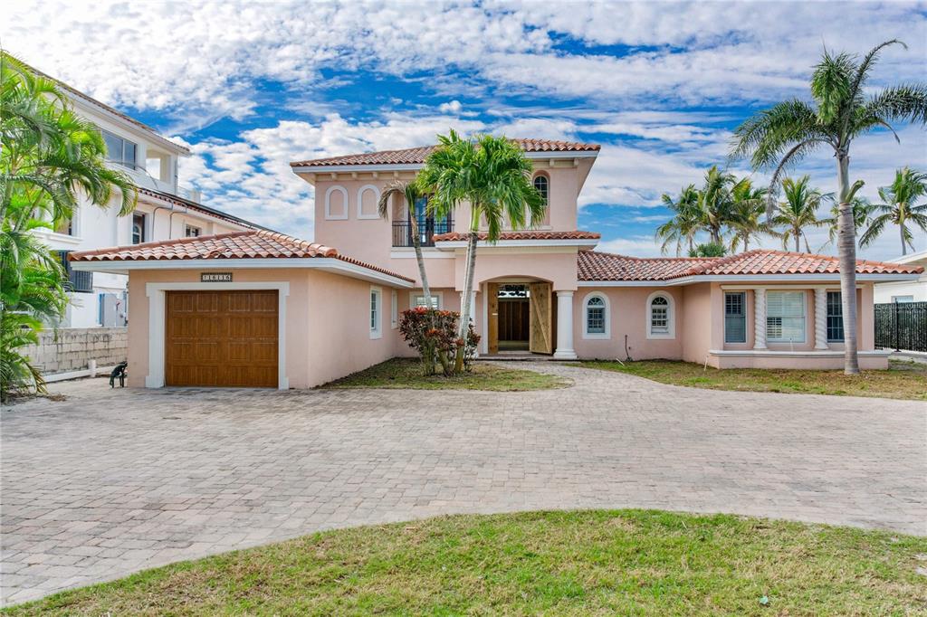 A two-story peach-colored house with a tile roof and a paved driveway — 16116 GULF BOULEVARD, REDINGTON BEACH, FL