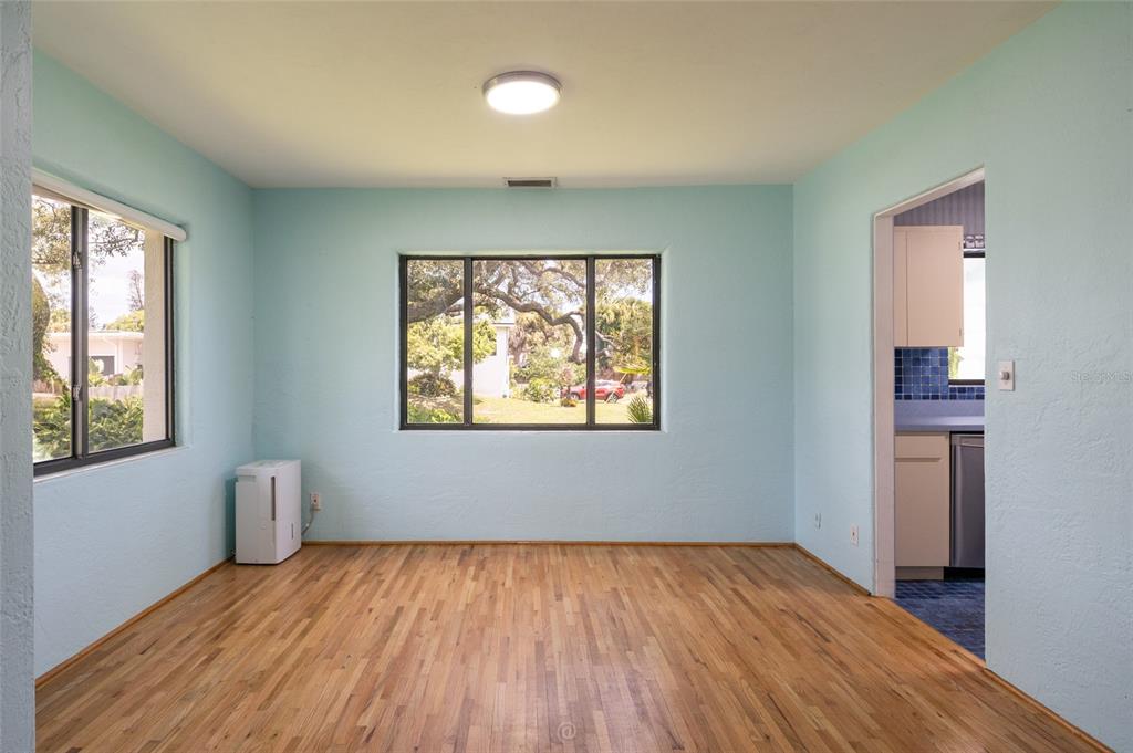 The exterior of a light blue house features a large window wall and a yard — 1460 N PENINSULA DRIVE, DAYTONA BEACH, FL