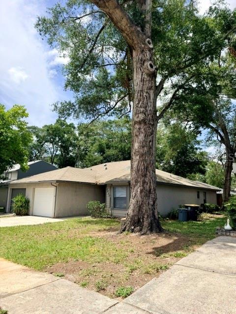 A single-story house with a tan exterior and a large tree in the front yard — 5627 GREATPINE LANE N, JACKSONVILLE, FL