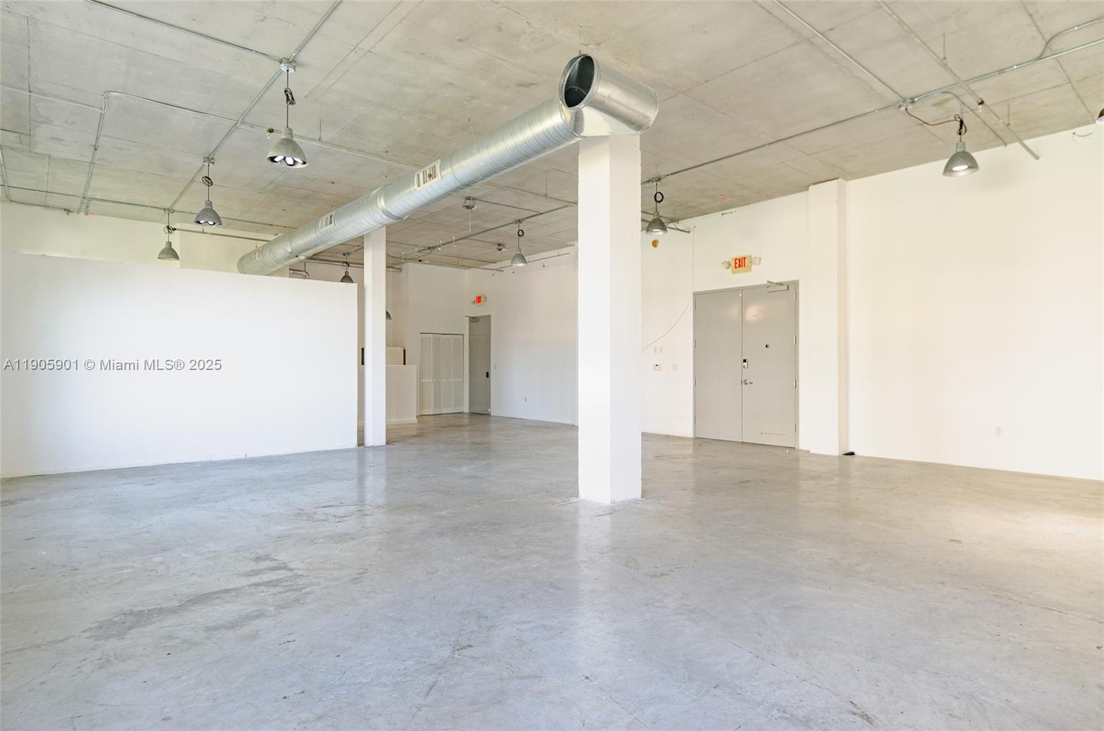 An open-plan commercial space features concrete floors, exposed ductwork, and white walls — 250 NW 23rd # 202, Miami FL 33127, MIAMI, FL