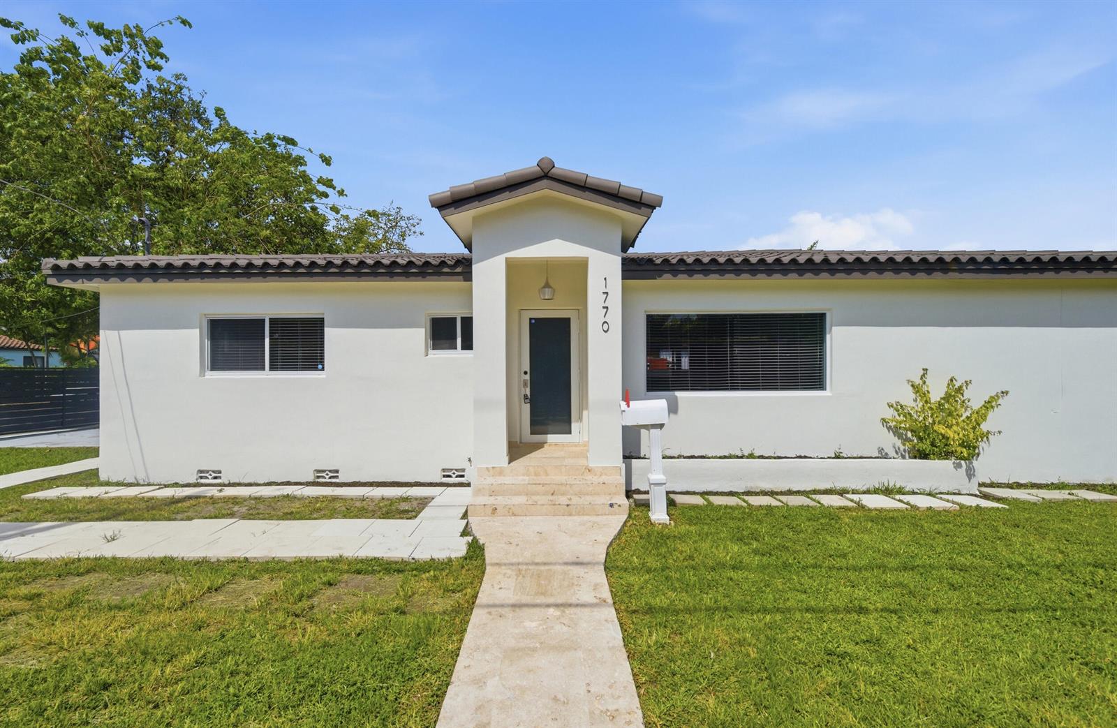 A single-story white house with a tiled roof, central entryway, and a front lawn — 1770 SW 17th Avenue, Miami FL 33145, MIAMI, FL