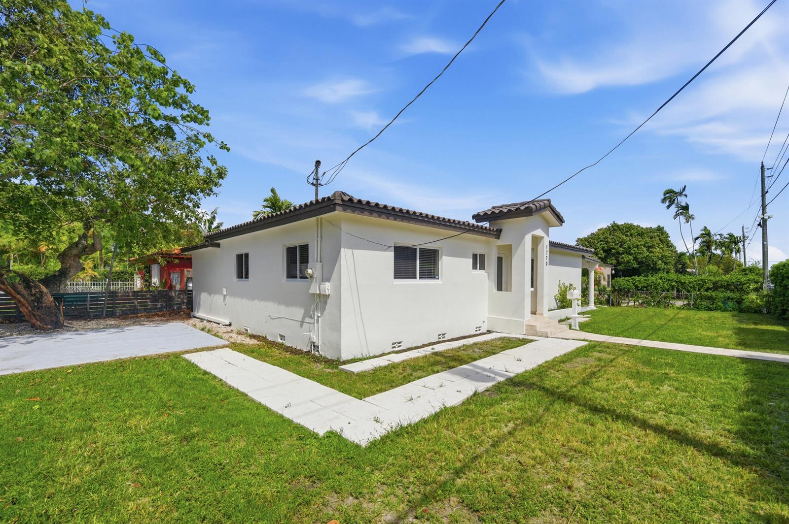 A white single-story house with a tiled roof stands on a grassy lot — 1770 SW 17th Avenue, Miami FL 33145, MIAMI, FL