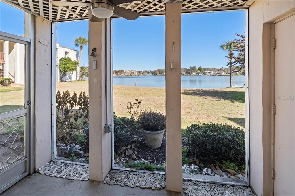 A screened-in porch overlooks a grassy lawn and a lake — 530 ORANGE DRIVE UNIT 11, ALTAMONTE SPRINGS, FL