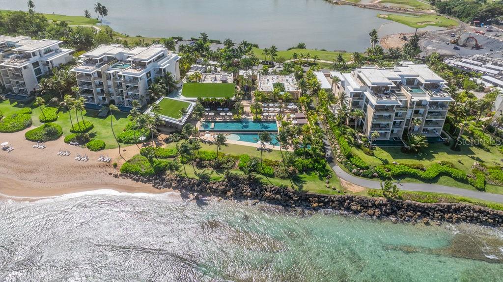 Aerial view of luxury beachfront condominiums with a central swimming pool and landscaped grounds — 200 Dorado Beach Dr WEST BEACH PH UNIT 3141-3142, DORADO, PR