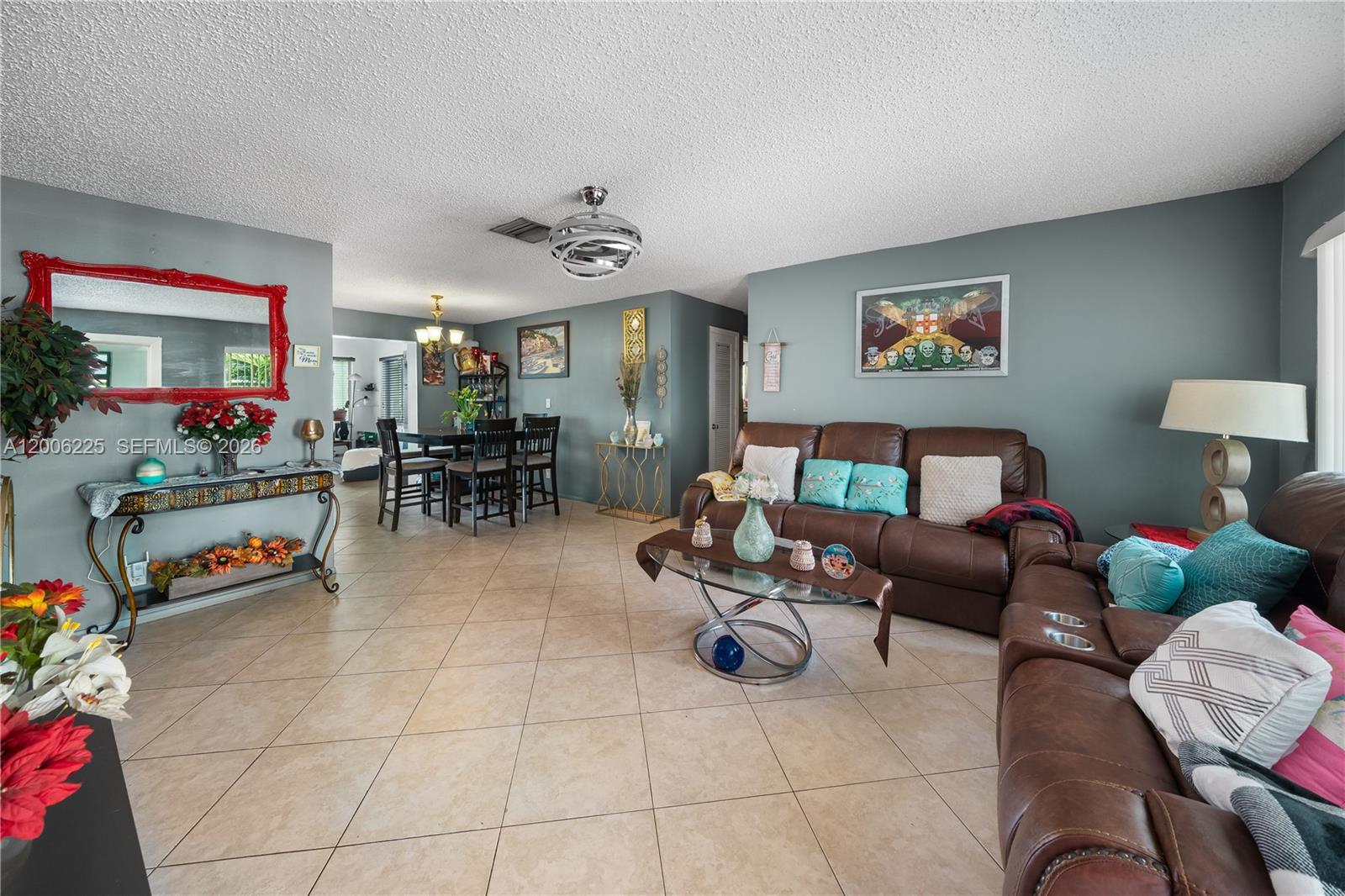A living room and dining area with tile floors, brown leather sofas, and gray walls — 4402 NW 44th Ave, Tamarac FL 33319, TAMARAC, FL