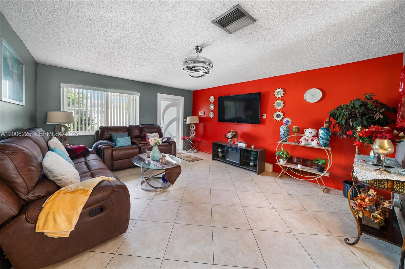 A living room features a red accent wall, brown leather sofa, and tile flooring — 4402 NW 44th Ave, Tamarac FL 33319, TAMARAC, FL
