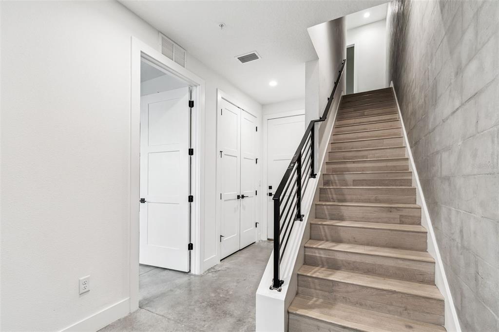 A staircase with wood treads and a black metal railing leads to an upper level — 2724 5TH AVENUE S, ST PETERSBURG, FL