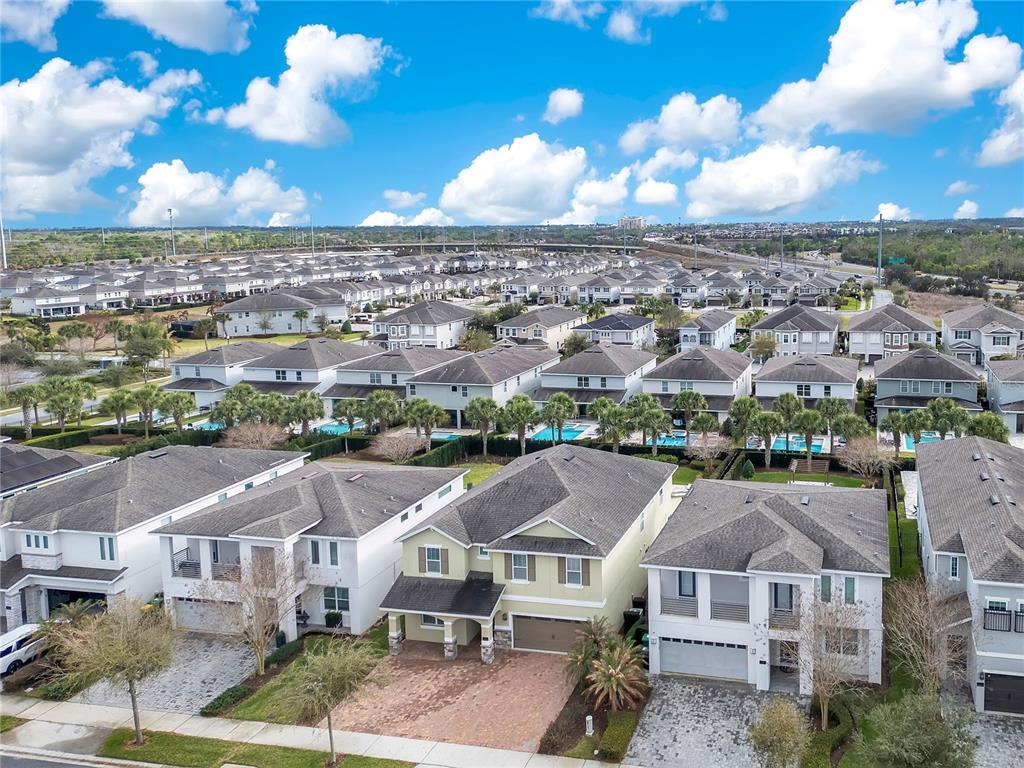 An aerial view shows a suburban neighborhood with rows of two-story houses and swimming pools — 210 BURMA STREET, KISSIMMEE, FL