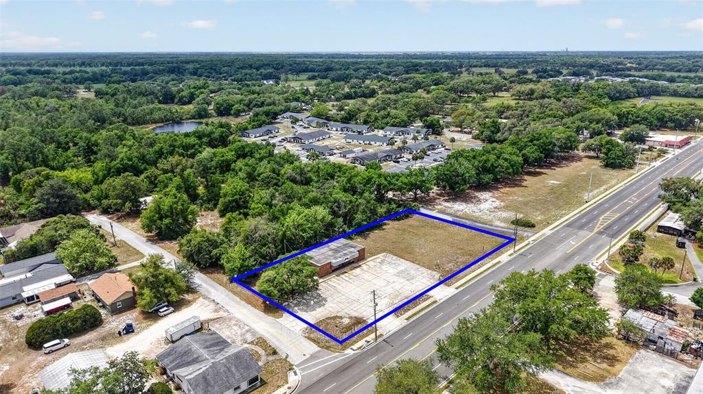 An aerial view shows a vacant commercial lot with a small building and concrete pad — 2501 SOUTH STREET, LEESBURG, FL