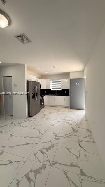 A kitchen with white cabinets, stainless steel appliances, and white marble-patterned tile flooring — 811 E 52nd St # 102, Hialeah FL 33013, HIALEAH, FL
