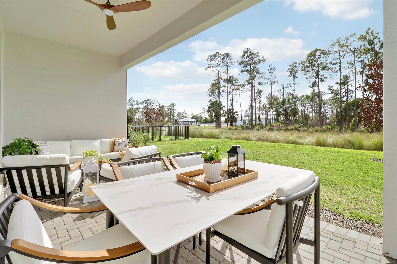 A bright white kitchen features a large island, stainless steel appliances, and light wood flooring — 7030 SE Haven Lane, Stuart FL 34997, STUART, FL