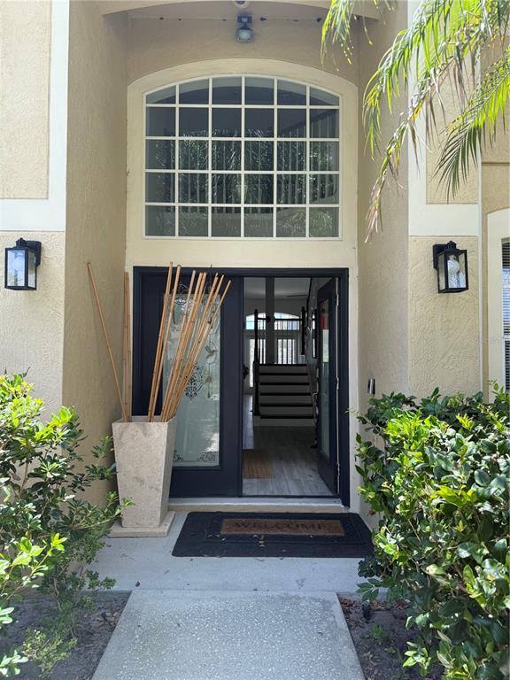 The exterior entrance features a dark front door, a large arched window, and two wall-mounted lanterns — 8040 SOLITAIRE COURT, ORLANDO, FL