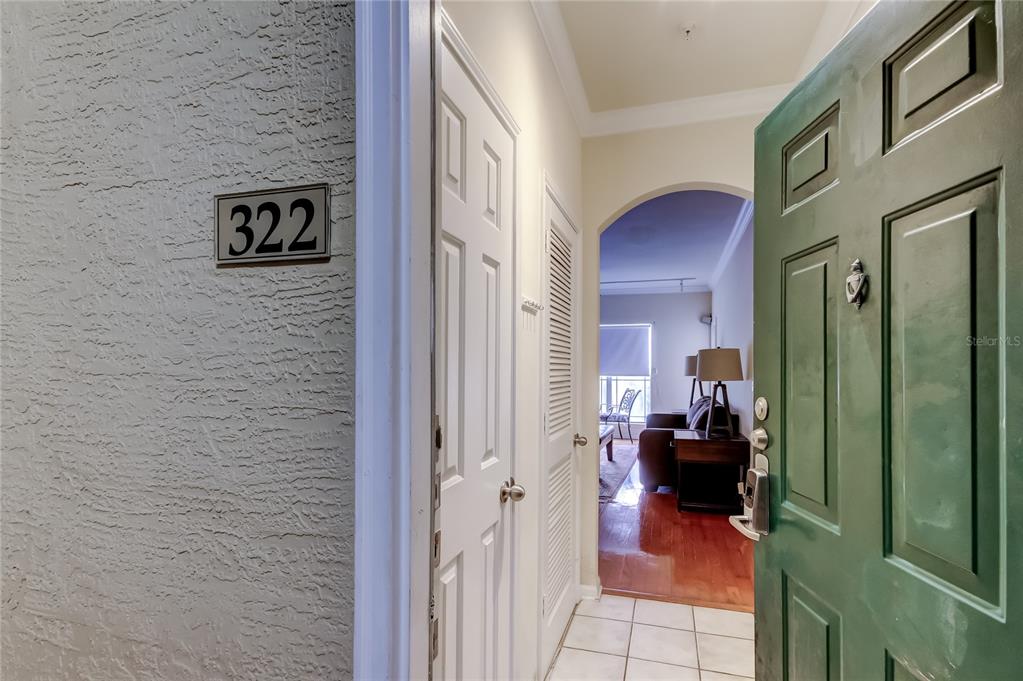 A view from an open green door into an apartment entryway with tiled floors — 1216 S MISSOURI AVENUE UNIT 322, CLEARWATER, FL