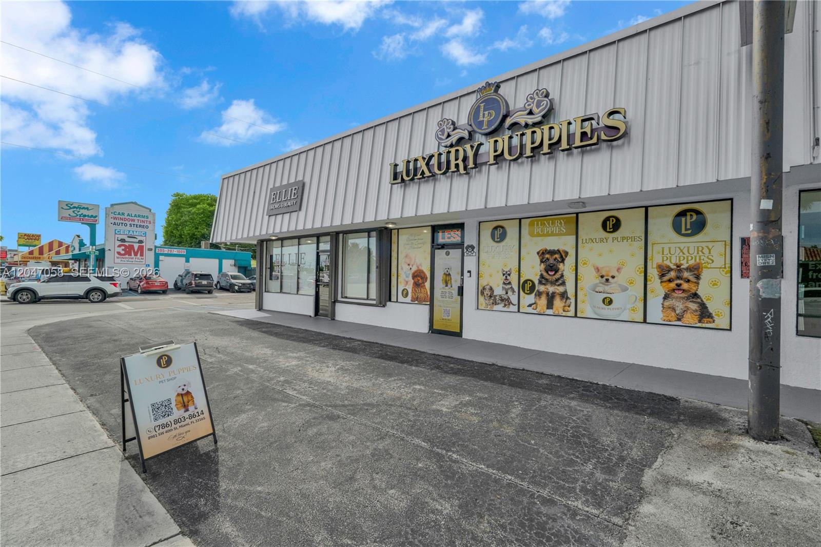 The exterior of a commercial building features a pet shop storefront with large puppy decals — 8981 SW 40th St, Miami FL 33165, MIAMI, FL