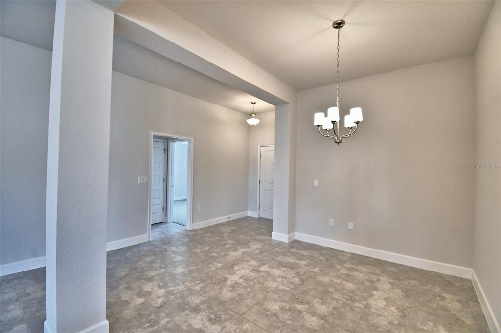 A dining area features light gray walls, tile flooring, and a modern chandelier — 4608 CALAMINT LANE, AUBURNDALE, FL