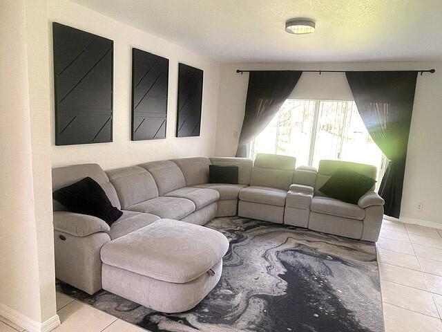 A living room features a light gray sectional sofa, a patterned rug, and wall art — 717 Talia Circle, Palm Springs FL 33461, PALM SPRINGS, FL