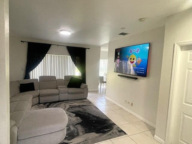 A living room features a light gray sectional sofa, a patterned rug, and a wall-mounted television — 717 Talia Circle, Palm Springs FL 33461, PALM SPRINGS, FL