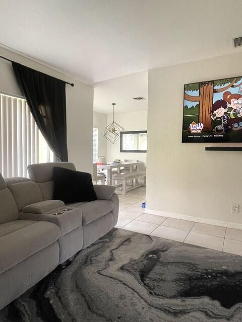 A living room features a gray sofa, a patterned rug, and a wall-mounted television — 717 Talia Circle, Palm Springs FL 33461, PALM SPRINGS, FL