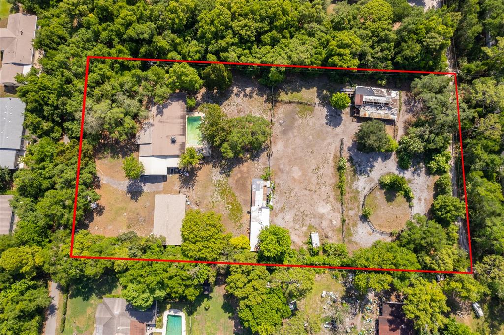 An aerial view shows a large, wooded lot containing a house with a pool and outbuildings — 1281 NATURES WAY, WINTER SPRINGS, FL
