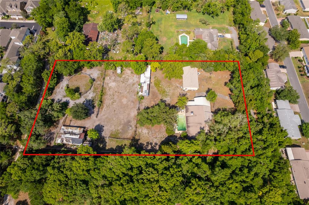 An aerial view shows a large, rectangular lot containing two houses, a pool, and trees — 1281 NATURES WAY, WINTER SPRINGS, FL