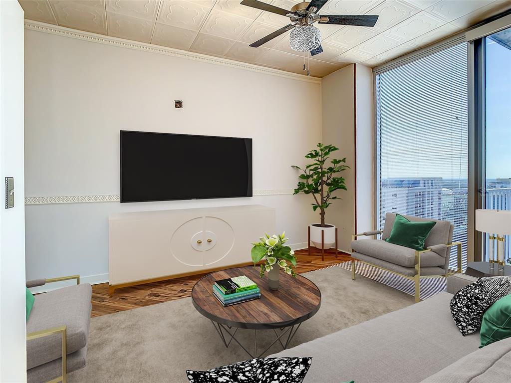 A living room features a wall-mounted television, a white media console, and floor-to-ceiling windows — 155 S COURT AVENUE UNIT 2107, ORLANDO, FL