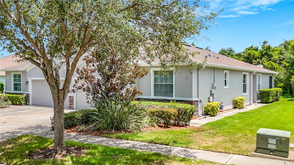 A single-story house with a gray exterior, a two-car garage, and a manicured lawn — 7434 SURREY PINES DRIVE, APOLLO BEACH, FL