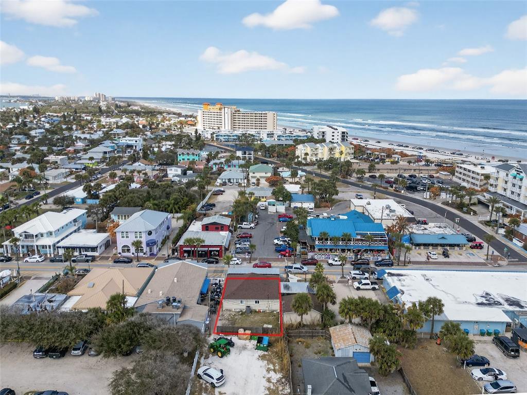 An aerial view shows a single-story building with a red outline in a coastal town — 411 FLAGLER AVENUE UNIT B, NEW SMYRNA BEACH, FL