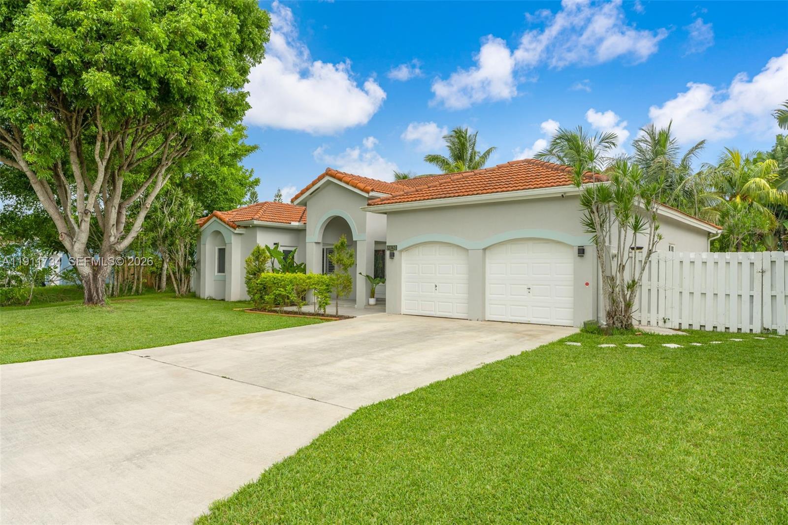 A single-story house with a red tile roof, two-car garage, and a large front tree — 12743 SW 220th St, Miami FL 33170, MIAMI, FL