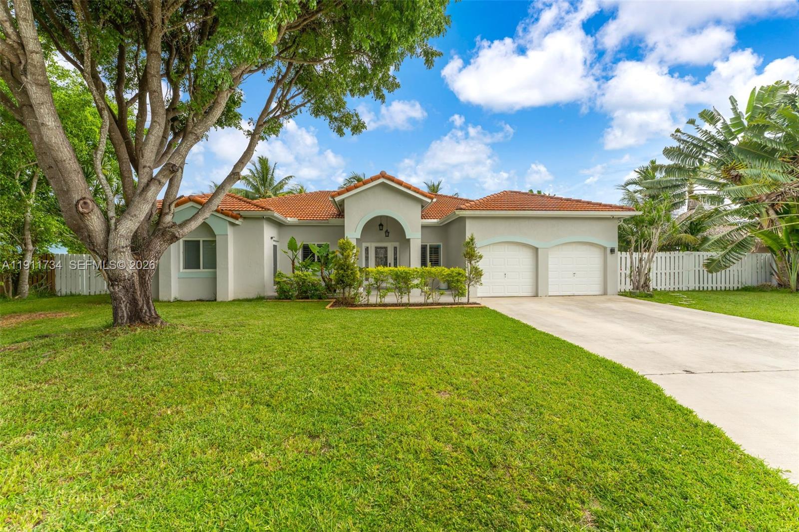 A single-story house with a tiled roof, two-car garage, and a large front tree — 12743 SW 220th St, Miami FL 33170, MIAMI, FL