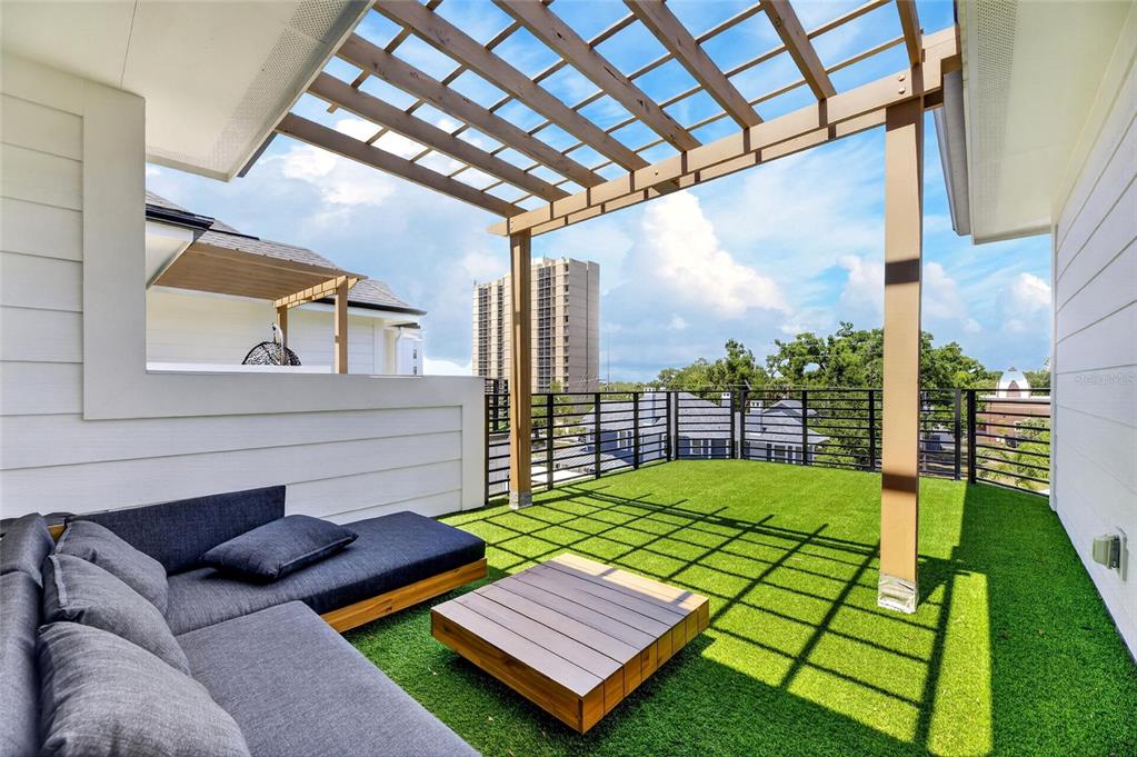 A rooftop terrace features artificial turf, a wooden pergola, and a modern sectional sofa — 1801 N MORGAN STREET UNIT 11, TAMPA, FL