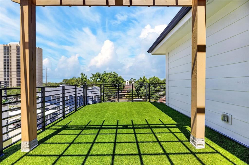 A rooftop terrace features artificial turf, a black metal railing, and a wooden pergola structure — 1801 N MORGAN STREET UNIT 11, TAMPA, FL