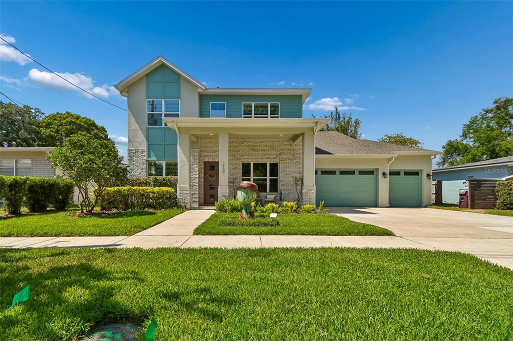 A two-story house with a brick facade, green siding, and a two-car garage — 2107 HARGILL DRIVE, ORLANDO, FL