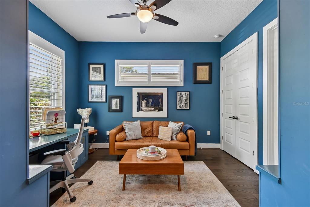 A home office features blue walls, a leather sofa, a desk, and a ceiling fan — 2107 HARGILL DRIVE, ORLANDO, FL