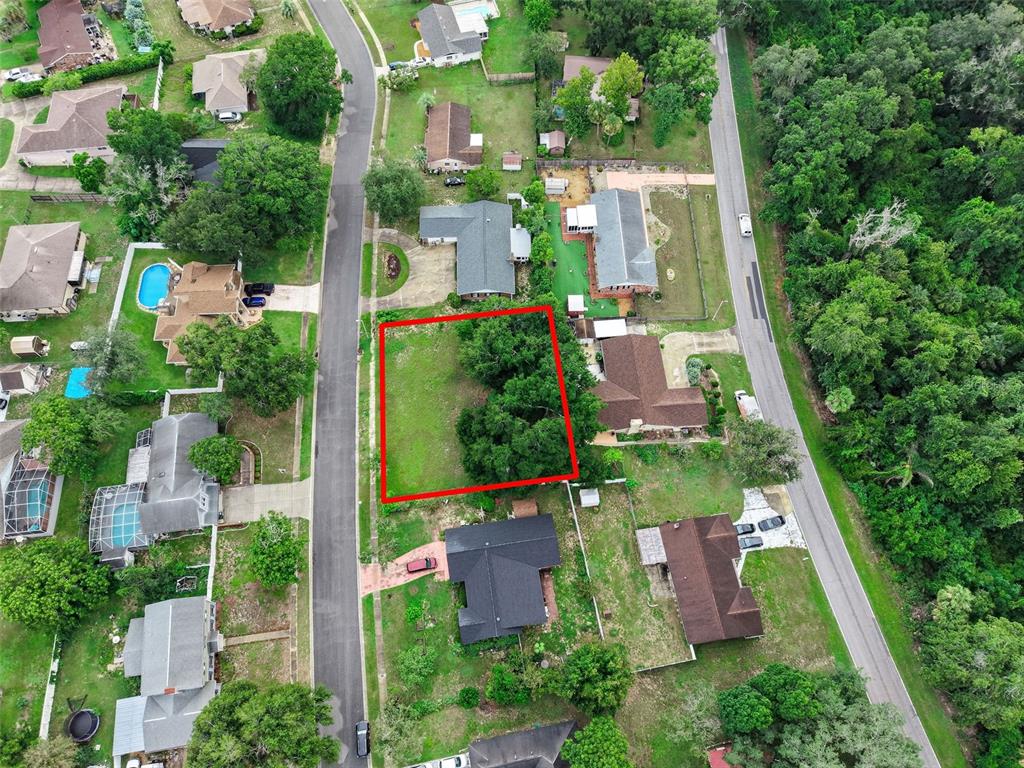 An aerial view shows a vacant, rectangular residential lot outlined in red between suburban houses — SAIL FISH AVENUE, FRUITLAND PARK, FL