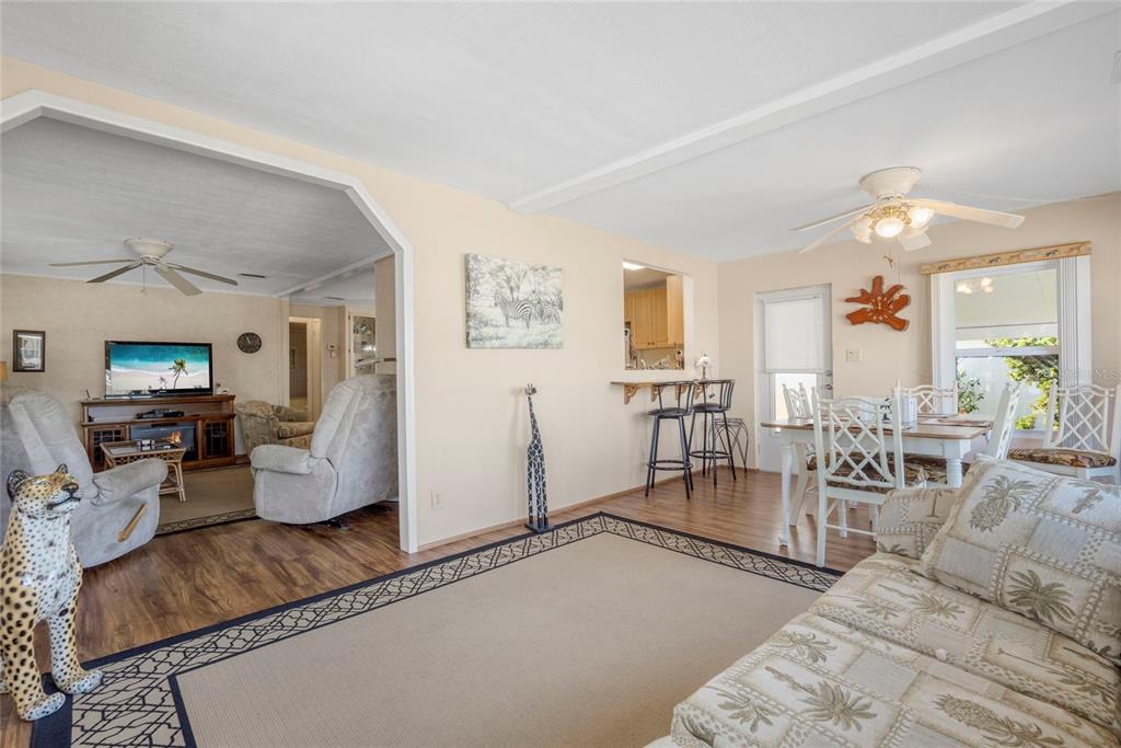 A living room and dining area feature wood-look flooring, a ceiling fan, and neutral walls — 533 FLEETWOOD STREET, NORTH PORT, FL