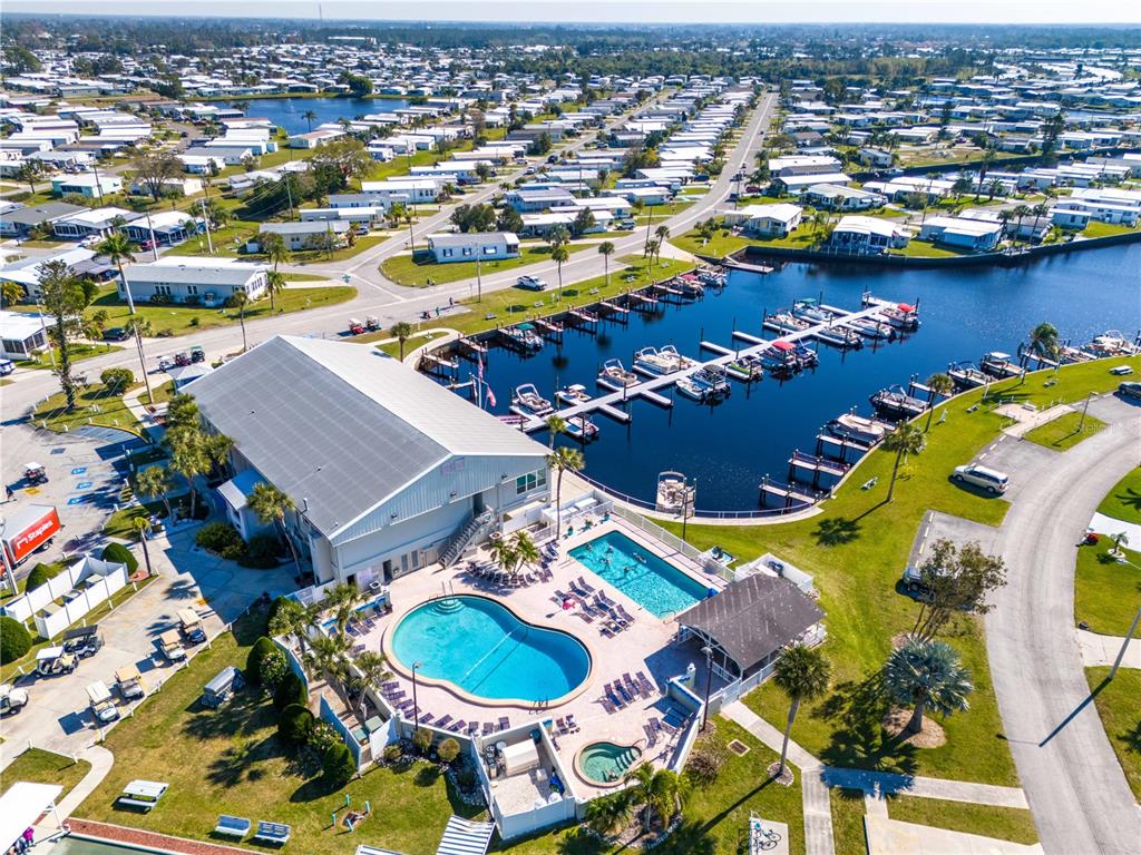 An aerial view shows a community clubhouse with two pools, a hot tub, and docks — 533 FLEETWOOD STREET, NORTH PORT, FL