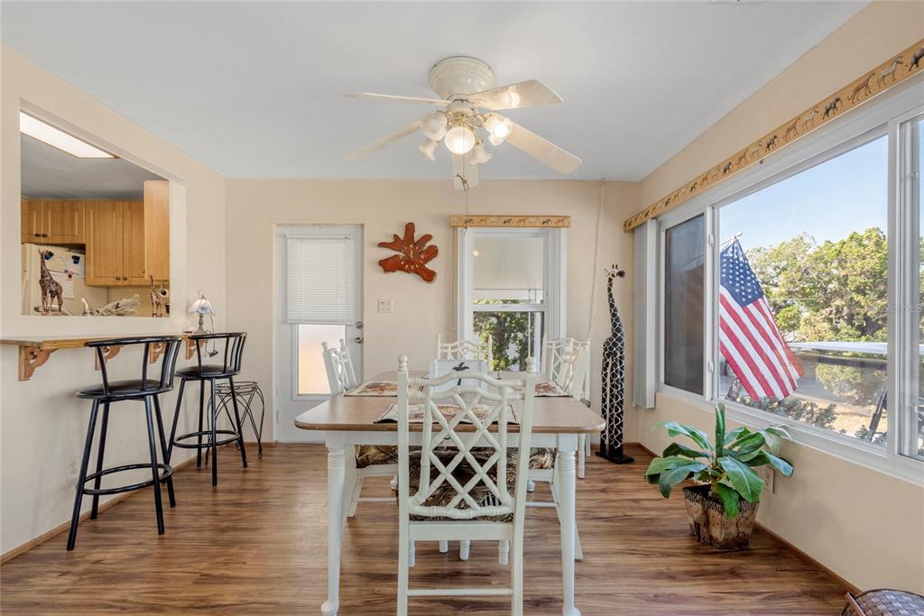 A dining area with a wooden table, white chairs, a ceiling fan, and a large window — 533 FLEETWOOD STREET, NORTH PORT, FL