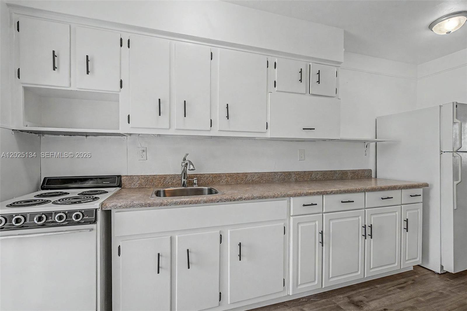 A kitchen features white cabinets, a speckled laminate countertop, a stainless steel sink, and appliances — 60 NW 79th St # 14, Miami FL 33150, MIAMI, FL