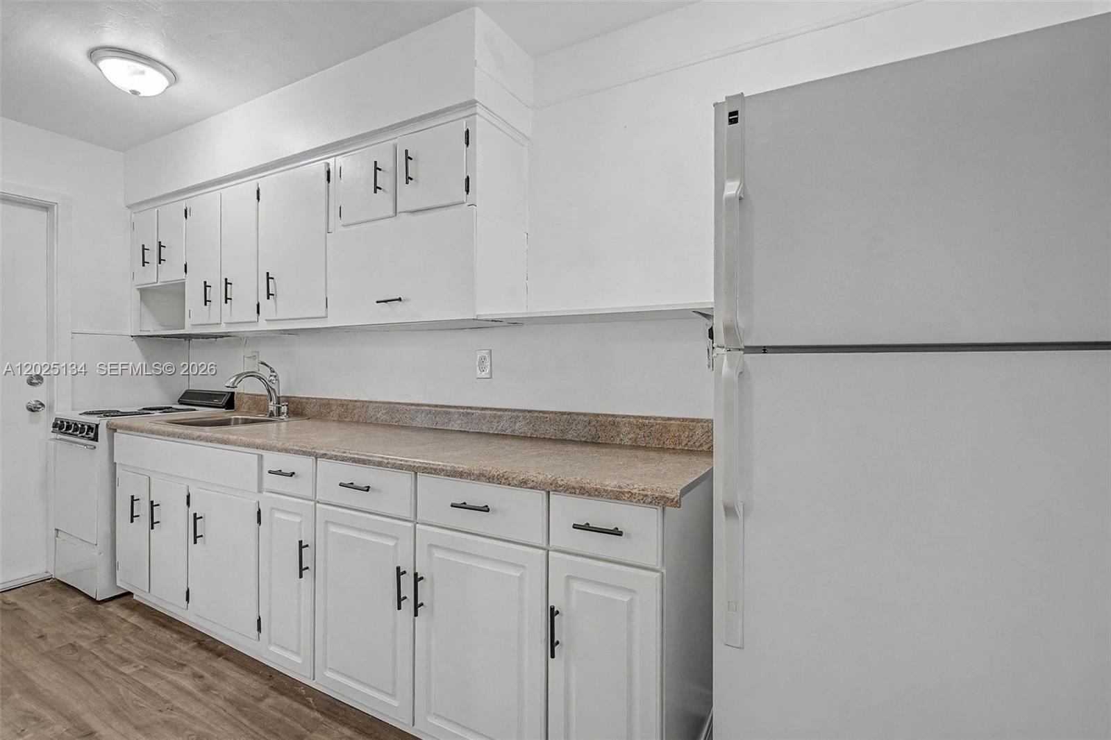 A kitchen features white cabinets, a speckled laminate countertop, and a white refrigerator — 60 NW 79th St # 14, Miami FL 33150, MIAMI, FL