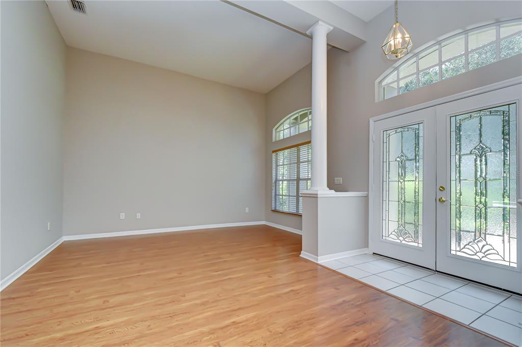 An entryway with wood flooring, a white pillar, and double glass-paneled doors — 3512 CORDGRASS DRIVE, VALRICO, FL