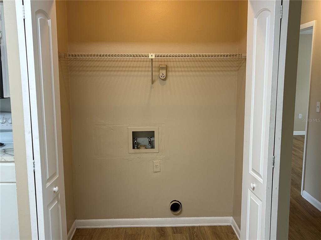 A laundry closet features a wire shelf, plumbing hookups, and a dryer vent on the wall — 5101 S CLARICE COURT UNIT 1C, TAMPA, FL