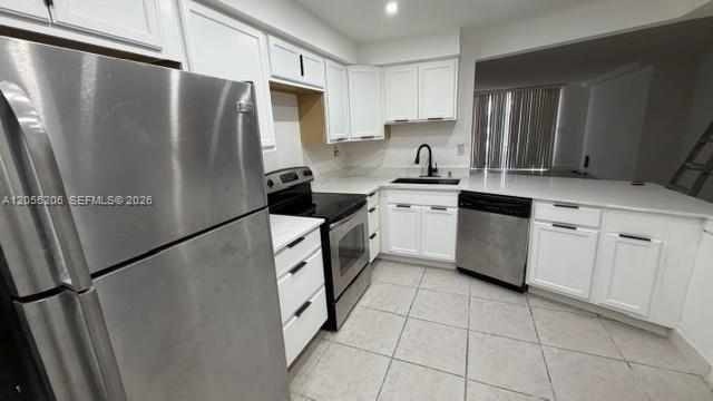 A kitchen with white cabinets, stainless steel appliances, and light-colored tile flooring — 1660 NE 191st St # 1, Miami FL 33179, MIAMI, FL