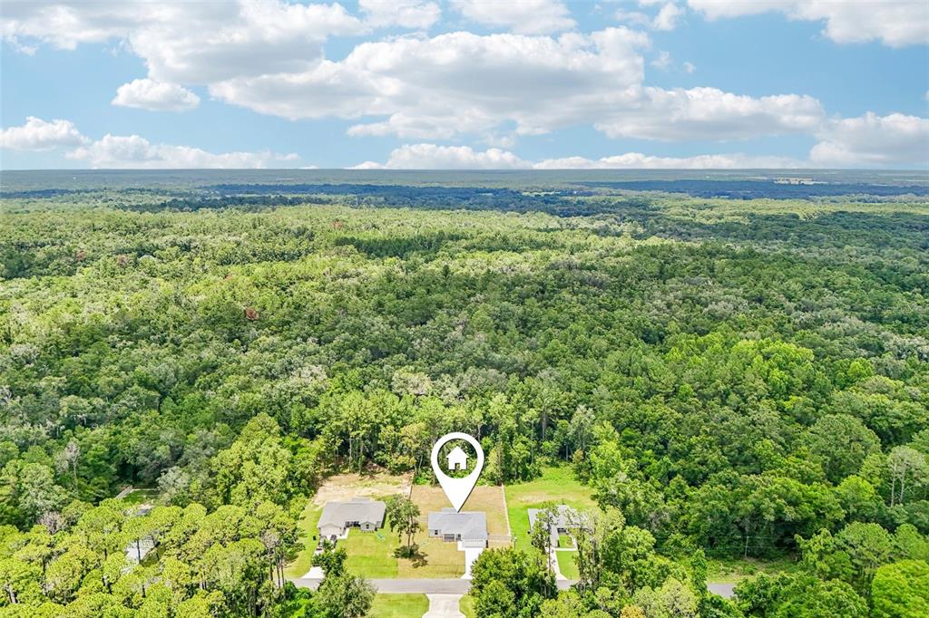 An aerial view shows a single-story house surrounded by dense forest and neighboring properties — 353 W ERIDANI COURT, CITRUS SPRINGS, FL