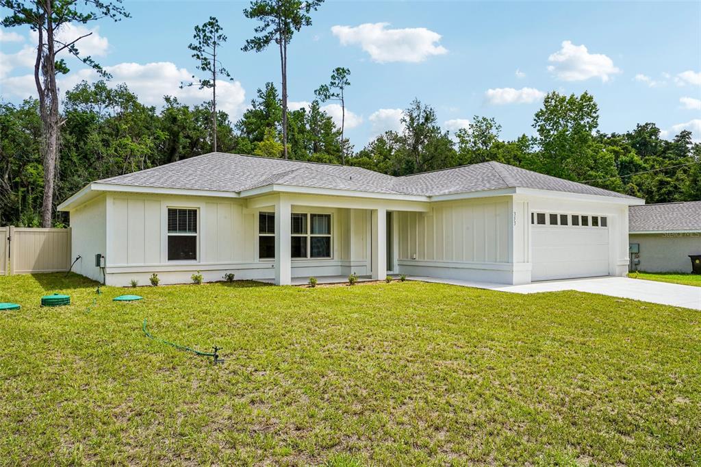 A single-story house with white vertical siding, a covered porch, and an attached two-car garage — 353 W ERIDANI COURT, CITRUS SPRINGS, FL